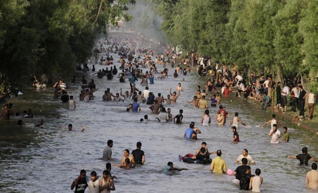 Pakistan Heat Wave : People cool off themselves in a canal in Lahore, Pakistan, where temperature reached 42 degrees Celsius 