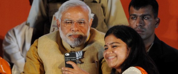 Chief Minister of the Indian state of Gujarat and Bharatiya Janata Party (BJP) prime ministerial candidate Narendra Modi (L) poses for a photograph as party candidate from Mumbai Poonam Mahajan takes a 'selfie' with him at an election rally in Mumbai on April 21, 2014. India's 814-million-strong electorate is voting in the world's biggest election which is set to sweep the Hindu nationalist opposition to power at a time of low growth, anger about corruption and warnings about religious unrest. AFP PHOTO/INDRANIL MUKHERJEE (Photo credit should read INDRANIL MUKHERJEE/AFP/Getty Images)