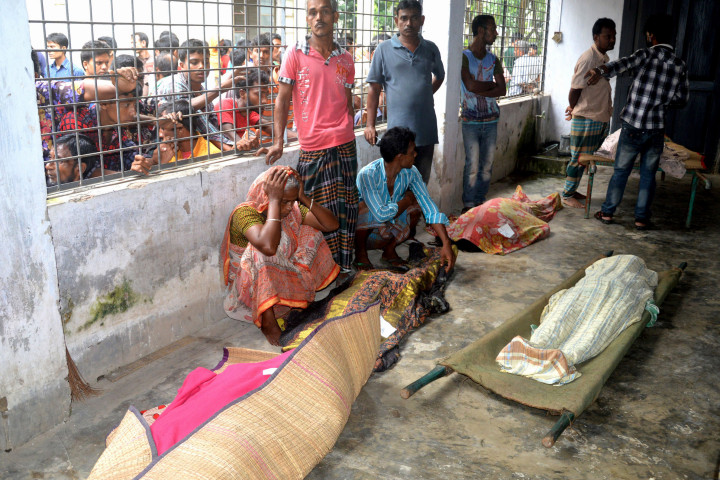 An elderly woman grieves next dead bodies at Mymensingh Medical College Hospital in the town of Mymensingh, 115 kilometers (70 miles) north of Dhaka, Bangladesh, Friday, July 10, 2015. The victims died on a stampede when hundreds of people stormed the home of a businessman for a charity handout during the holy Muslim month of Ramadan, police said. (AP Photo/Jahangir Kabir Jewel)