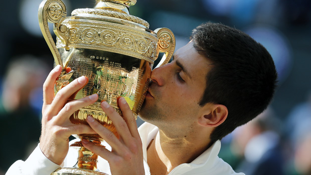 Novak Djokovic of Serbia kisses the trophy after defeating Roger Federer of Switzerland in the men's singles final at the All England Lawn Tennis Championships in Wimbledon, London, Sunday July 6, 2014. (AP Photo/Ben Curtis)