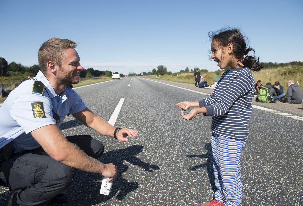 danish police with syrian refugee girl