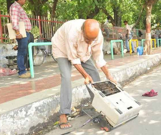 Old man taking his typewriter which is damaged by Police