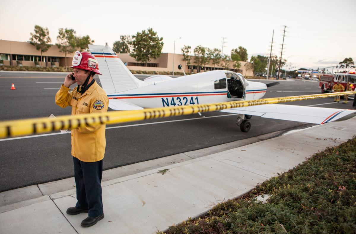 orange County Fire Authority Steve Concialdi does a phone interview after a Piper Cherokee aircraft with and instructor and student made an emergency landing on Red Hill Avenue and MacArthur Boulevard around 6:15 p.m. Wednesday night in Irvine. ADDITIONAL INFORMATION: KEVIN WARN, CONTRIBUTING PHOTOGRAPHER - 09/16/15 - A small plane with student pilots aboard made an emergency landing on an Irvine street Wednesday evening, authorities said. A Piper Cherokee aircraft with an instructor and the students landed at 6:18 p.m. near John Wayne Airport at Red Hill Avenue and MacArthur Boulevard, said Capt. Steve Concialdi of the Orange County Fire Authority. No injuries were reported. The total number of people on board was not immediately available. The southbound lanes of Red Hill Avenue are closed until further notice. No cause for the landing was released. More to come