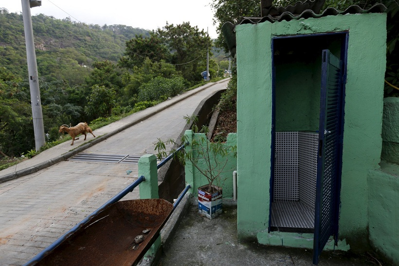 A dog runs past a bar toilet in the Turano slum in Rio de Janeiro, Brazil, October 1, 2015. 