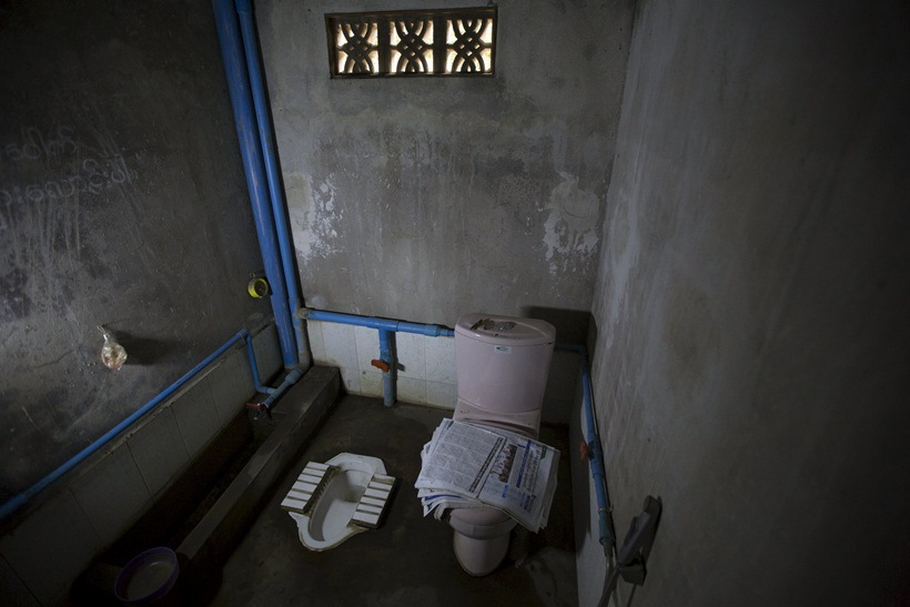 Newspapers lie on a toilet seat in a house in Mandalay, Myanmar, October 5, 2015. 