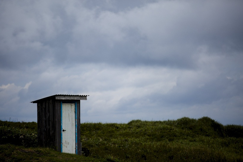 A toilet stands in a field on private property in the town of Yuzhno-Kurilsk on Kunashir Island which is part of the Kuril Islands group in Russia