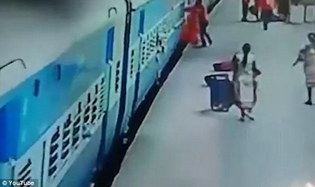 woman dragged down under train track