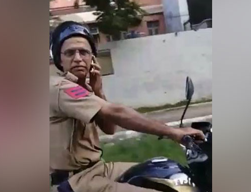 police driving bike while talking on the phone