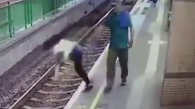 Man shoves unsuspecting woman onto train tracks