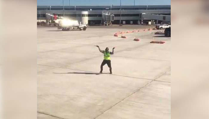 Airport worker entertaining passengers with his dance moves