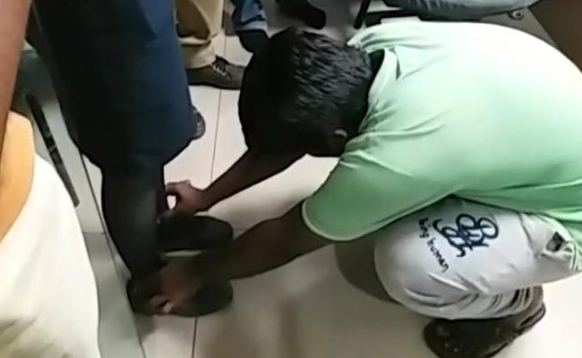 man touching Indigo employee feet for misbehaving