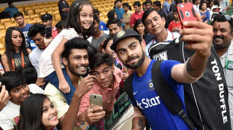 Virat Kohli clicking selfie with fans
