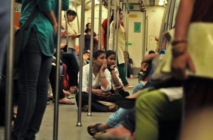 Commuters sitting on the floor in Metro